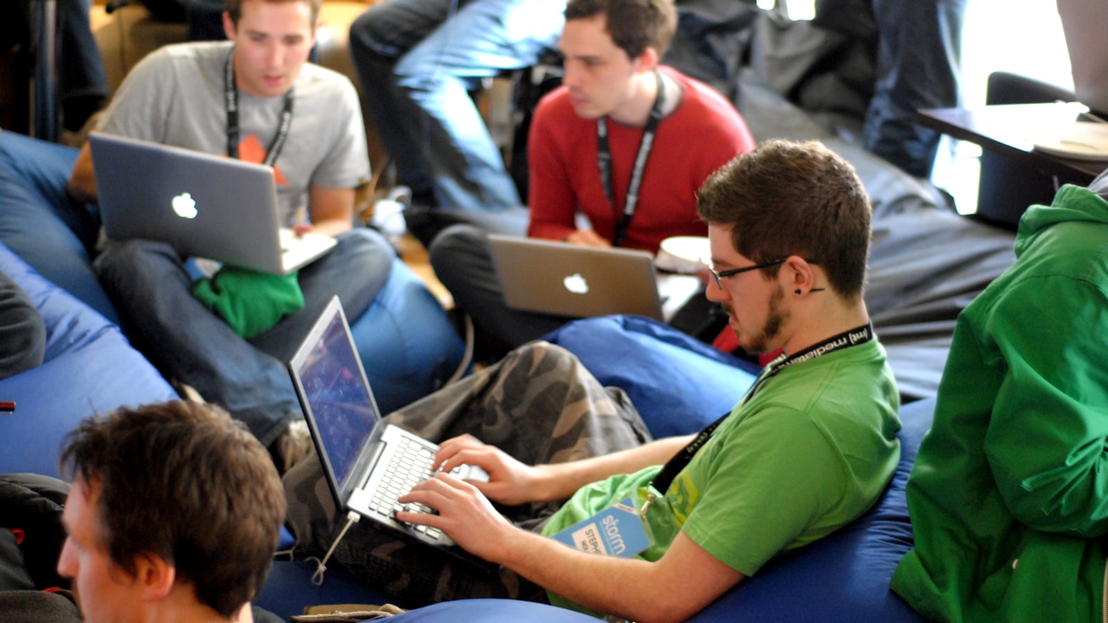 Man sitting on blue bean bag usinglaptop